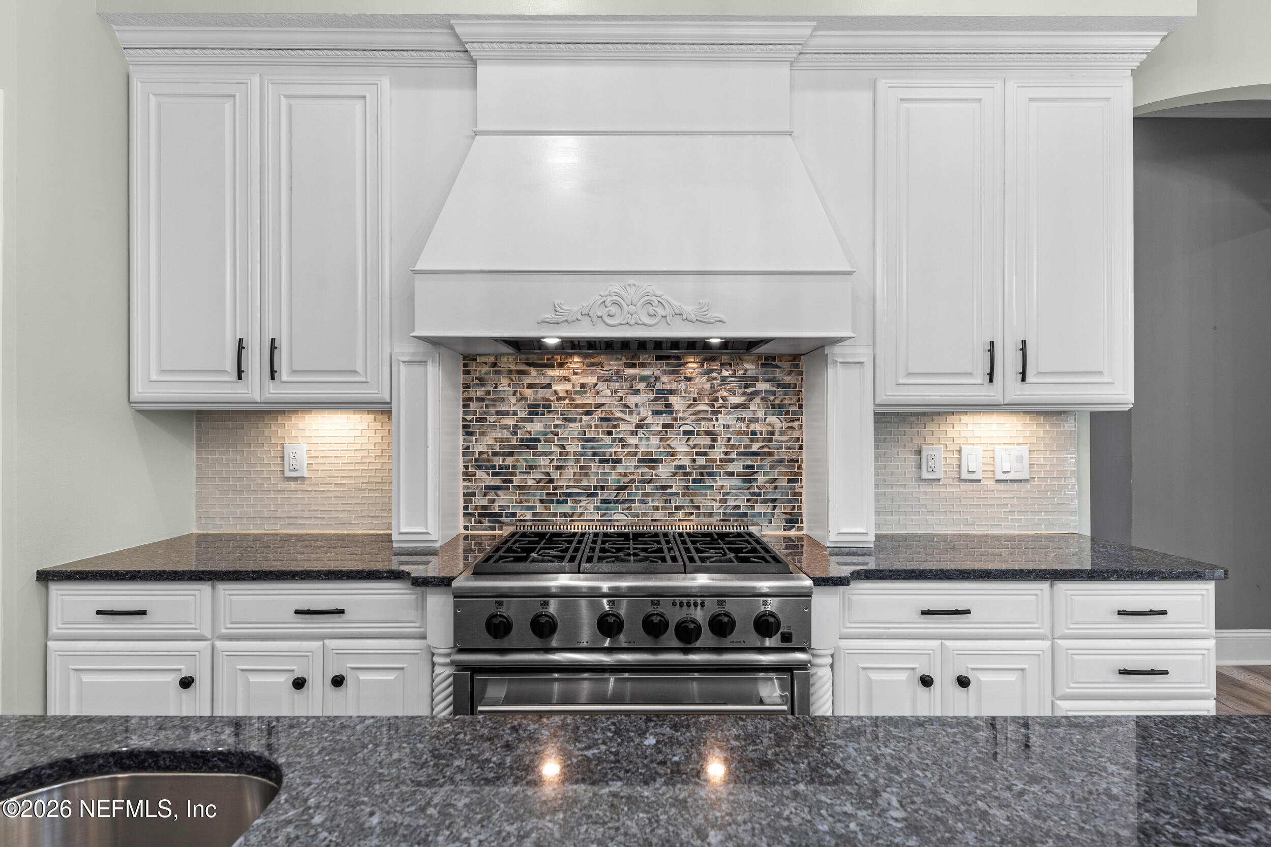 3225 Bishop Estates Road St. Johns, FL 32259 - Photo 17 of 90 a kitchen with white cabinets and a stove with a fireplace