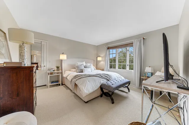 a bedroom with a bed and large windows