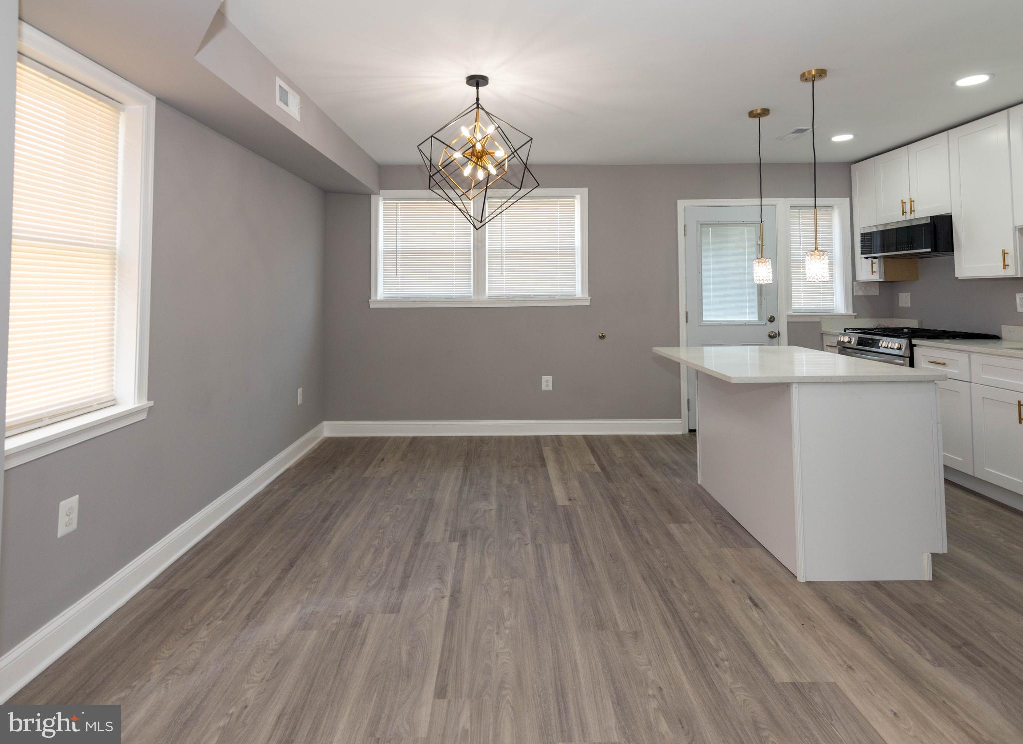 4843 Greencrest Road Baltimore, MD 21206 - Photo 8 of 44 a kitchen with cabinets wooden floor a window and appliances