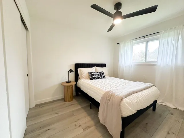 a bedroom with a bed and a ceiling fan