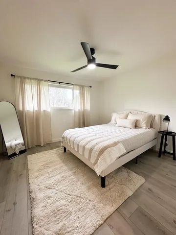 a bedroom with a large bed and a chair