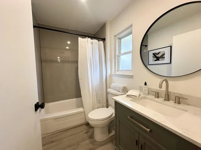 a bathroom with a granite countertop sink toilet and shower