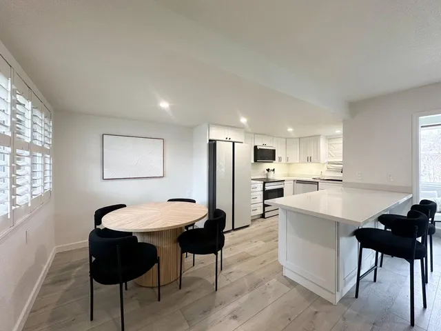 a kitchen with a table chairs refrigerator and window