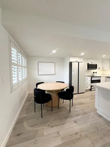 a living room with furniture a table and kitchen view
