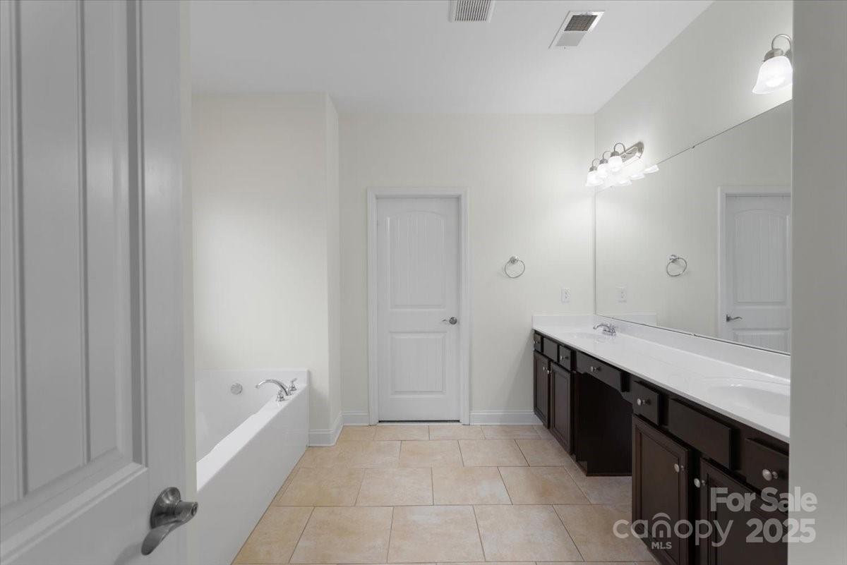 1011 Potomac Road Indian Trail, NC 28079 - Photo 17 of 34 a spacious bathroom with a granite countertop sink a mirror and a bathtub