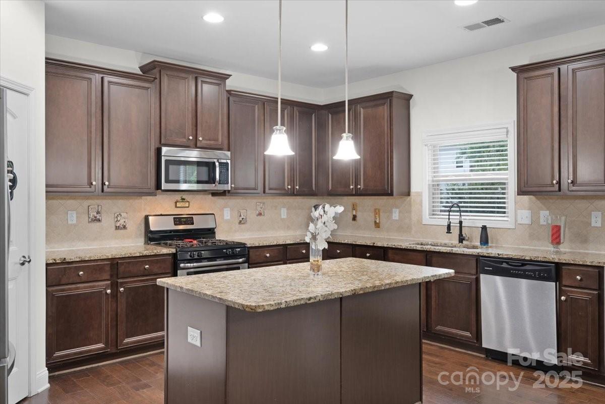 1011 Potomac Road Indian Trail, NC 28079 - Photo 8 of 34 a kitchen with a sink a stove a microwave and cabinets