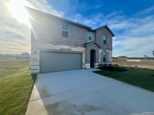 a front view of a house with a yard and garage