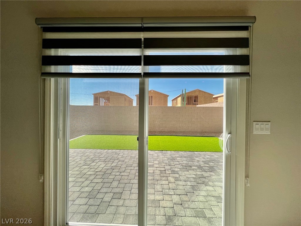 7845 Morganite Avenue Las Vegas, NV 89113 - Photo 9 of 21 Sliding glass doors open to a paver patio and artificial turf in the private yard.