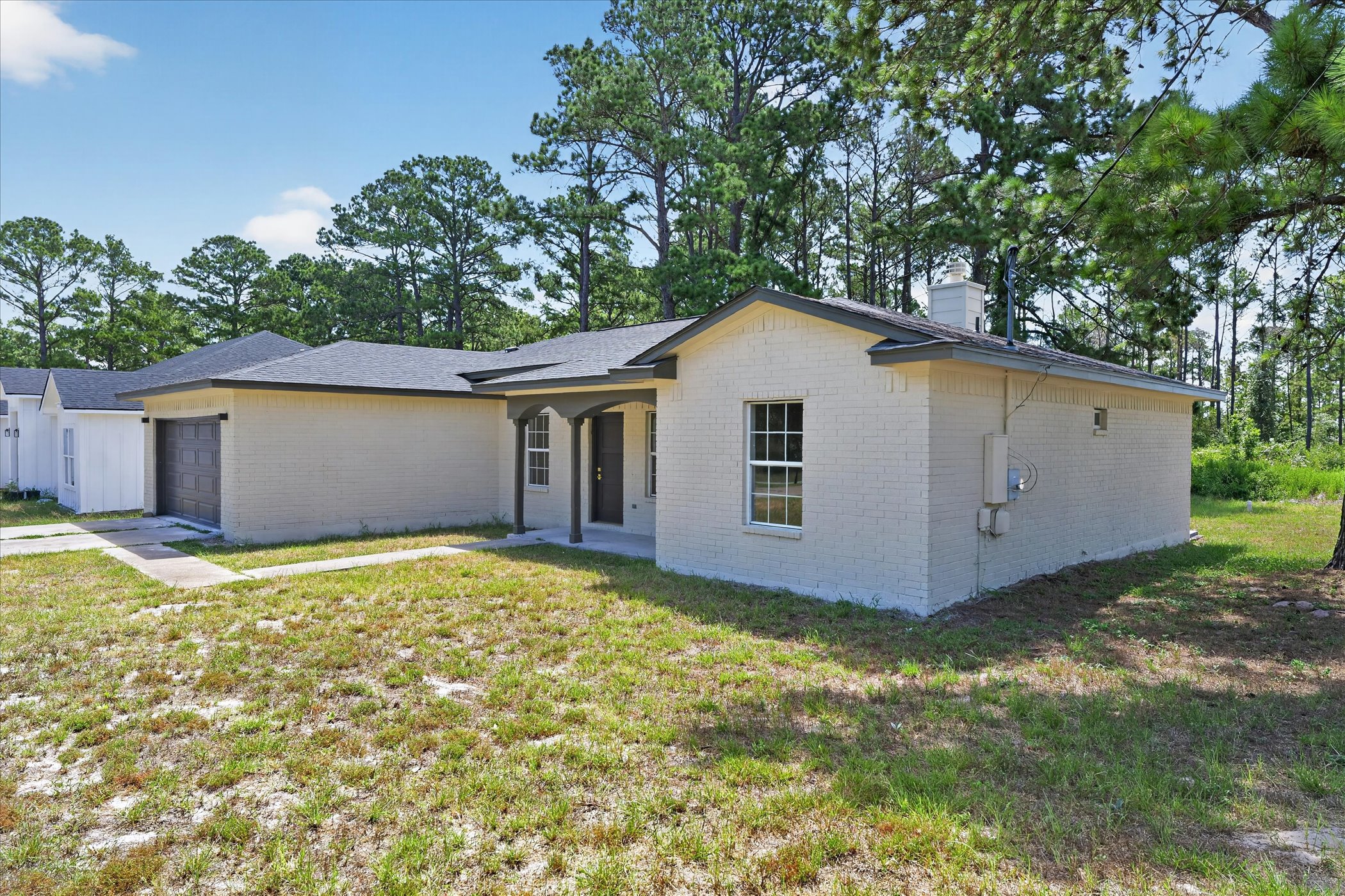 258 Pine View Loop Bastrop, TX 78602 - Photo 3 of 40 A quaint residence featuring a covered front entry and a convenient attached garage, nestled among mature trees.