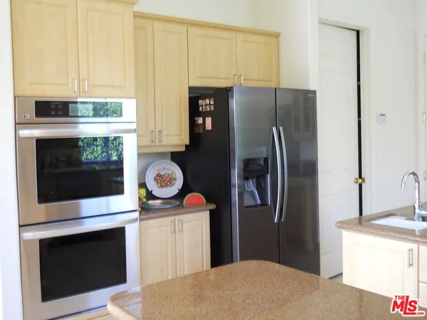 a kitchen with stainless steel appliances granite countertop a refrigerator a stove and a microwave