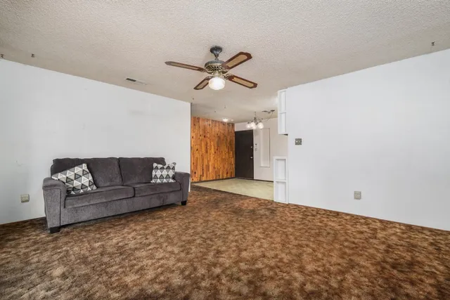 a living room with furniture and a ceiling fan