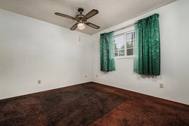 a view of a big room with wooden floor and windows