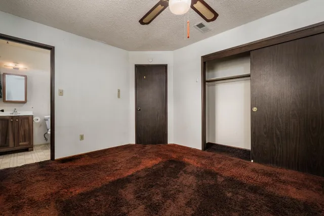 a view of empty room with ceiling fan and window