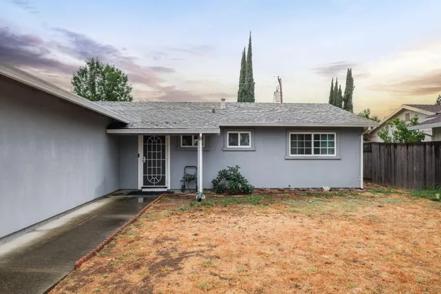 a view of backyard space with wooden fence