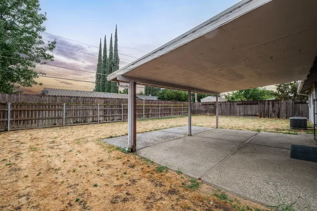 a view of a house with a barbeque and wooden fence
