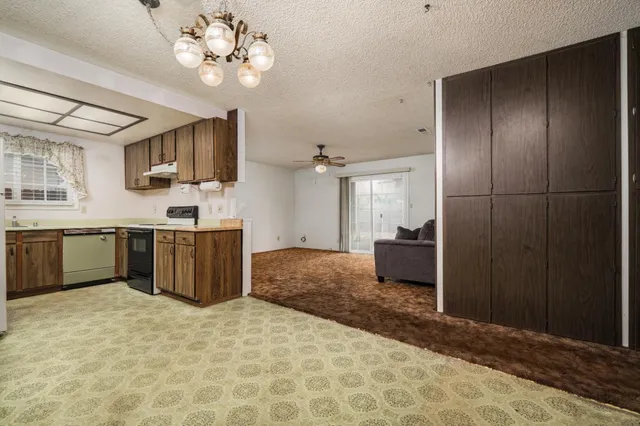 a kitchen with stainless steel appliances kitchen island granite countertop a refrigerator and a sink