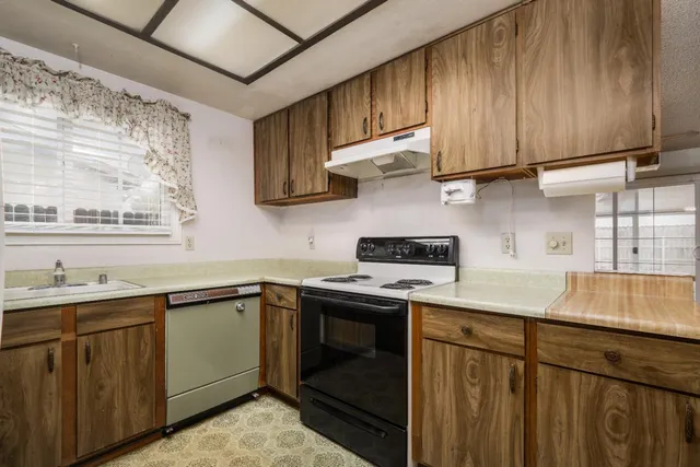 a kitchen with stainless steel appliances granite countertop a sink a stove and cabinets