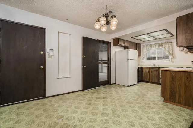 a view of a kitchen with a sink and refrigerator