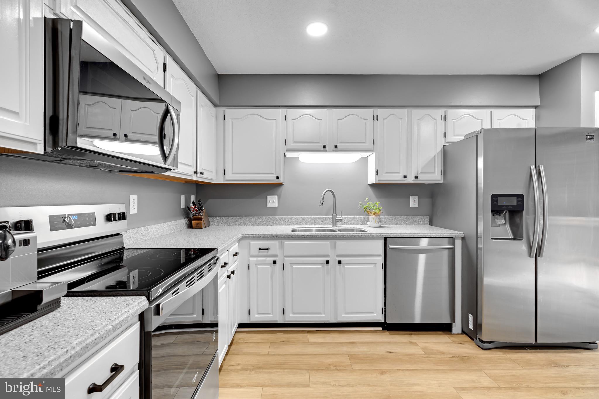 8110 Squirrel Run Road Springfield, VA 22152 - Photo 15 of 53 a kitchen with stainless steel appliances granite countertop a refrigerator a stove and a microwave