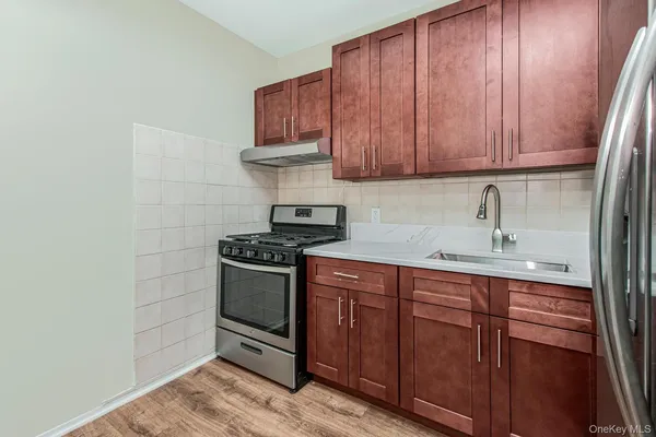 a kitchen with stainless steel appliances granite countertop a sink stove and cabinets
