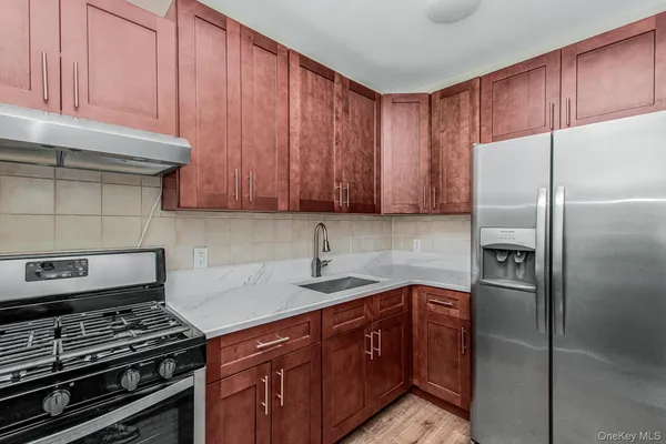 a kitchen with stainless steel appliances granite countertop a refrigerator and a stove top oven