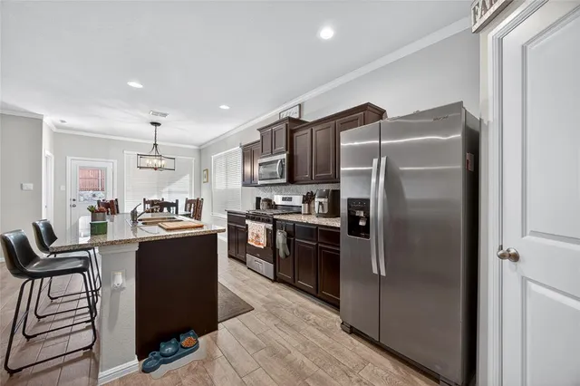 a kitchen with kitchen island a counter top space cabinets and stainless steel appliances