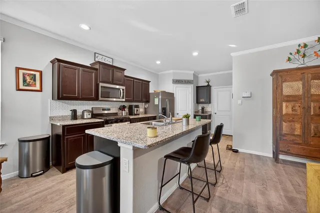 a kitchen with a table chairs microwave and refrigerator