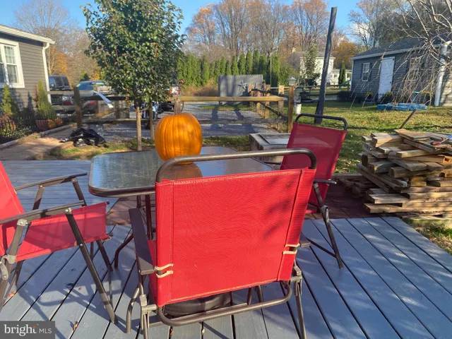 a view of a backyard with table and chairs potted plants and wooden fence