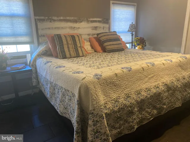 a bed sitting in a bedroom next to a window and a fireplace