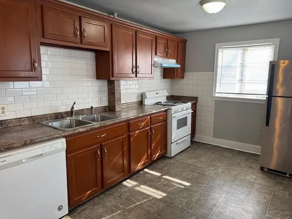a kitchen with stainless steel appliances granite countertop a sink stove and cabinets