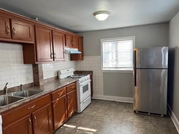 a kitchen with stainless steel appliances granite countertop a refrigerator a sink a stove a microwave and cabinets