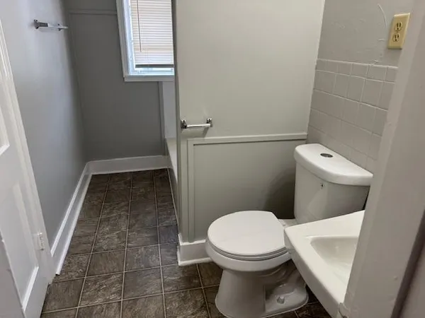 a white toilet sitting next to a shower