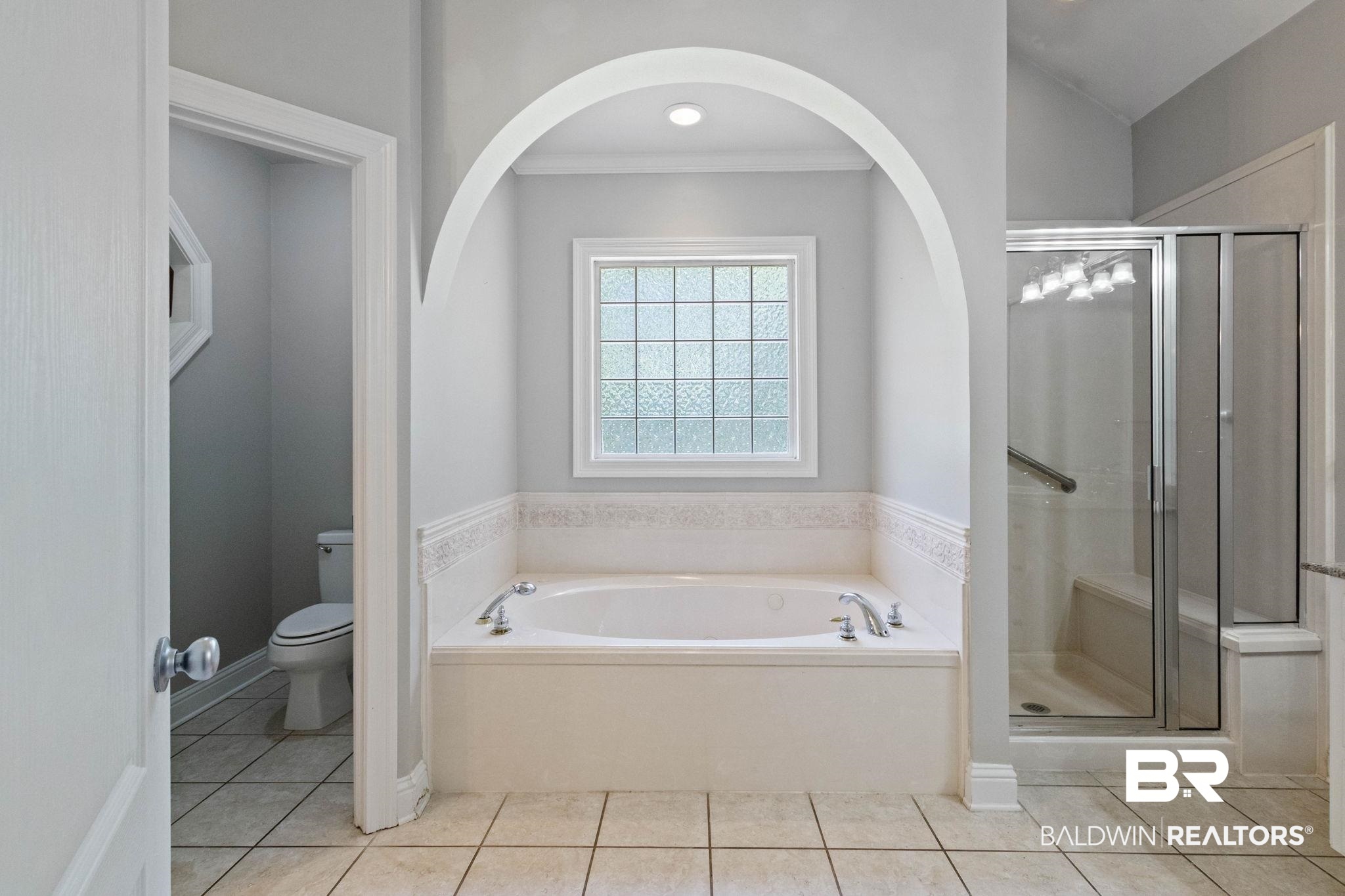 3176 Cedar Court Mobile, AL 36619 - Photo 16 of 33 Spacious bathroom featuring a soaking tub, glass-enclosed shower, and a separate commode area