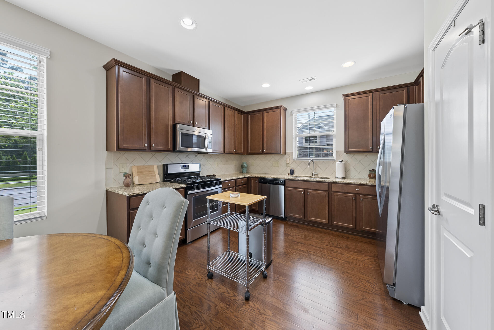 2 Intuition Circle Durham, NC 27705 - Photo 15 of 33 a kitchen with stainless steel appliances granite countertop a refrigerator a sink dishwasher a stove and a dining table with wooden floor