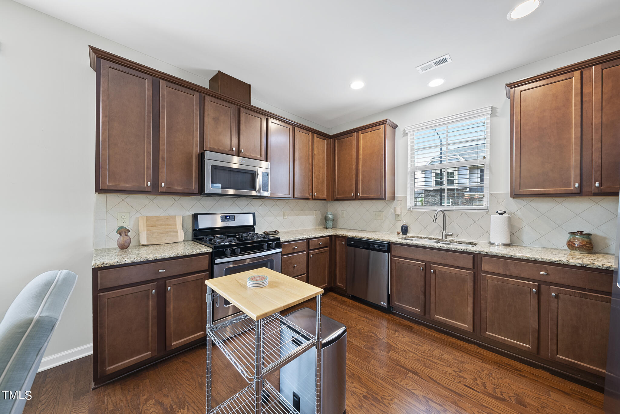 2 Intuition Circle Durham, NC 27705 - Photo 8 of 33 a kitchen with stainless steel appliances granite countertop wooden cabinets a stove a sink and dishwasher with wooden floor