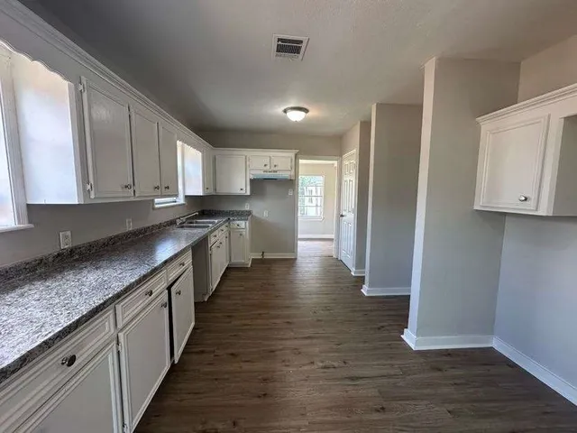 a large kitchen with stainless steel appliances granite countertop a stove a sink and a refrigerator