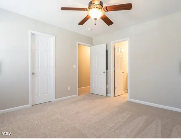 a view of empty room with window and a ceiling fan