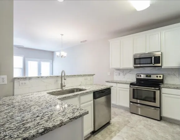 a kitchen with stainless steel appliances granite countertop a sink stove and microwave