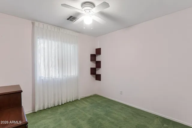 an empty room with closet and windows