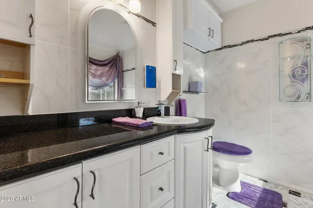 a bathroom with a granite countertop sink and a mirror