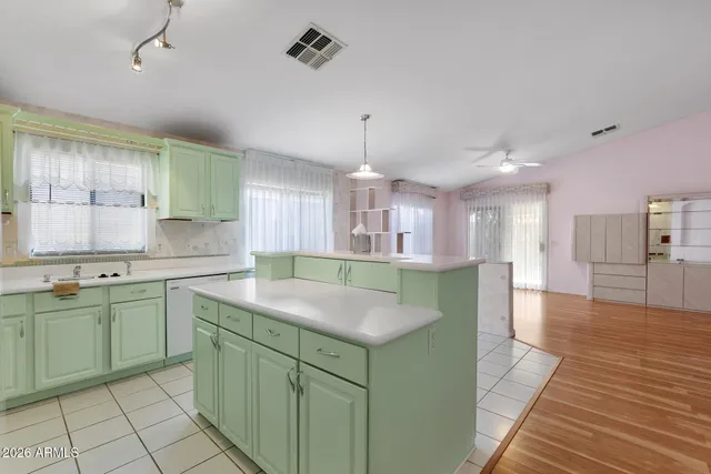 a kitchen with kitchen island granite countertop a sink a counter space appliances and cabinets