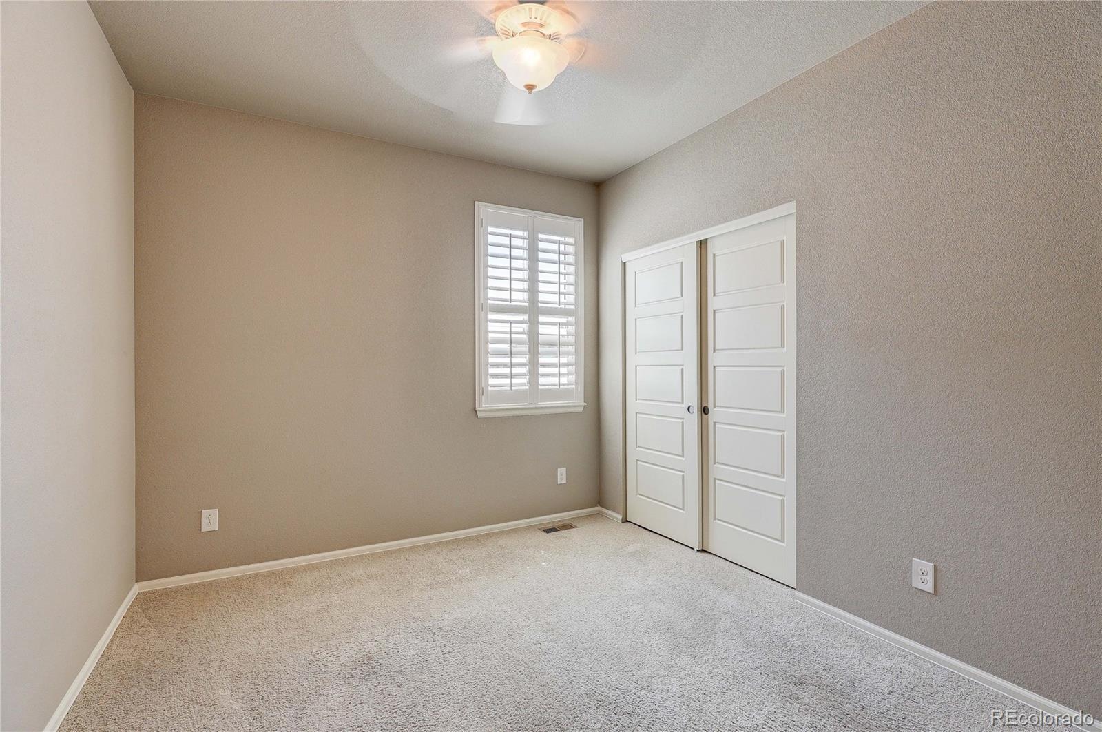 8891 Foxfire Street Firestone, CO 80504 - Photo 11 of 37 an empty room with chandelier fan and windows