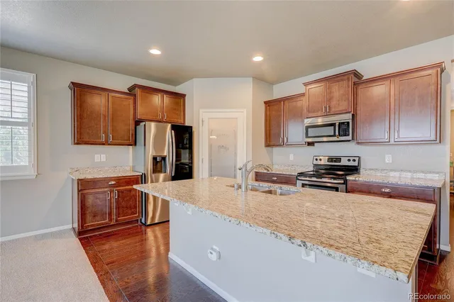 a kitchen with stainless steel appliances granite countertop a refrigerator stove microwave and sink
