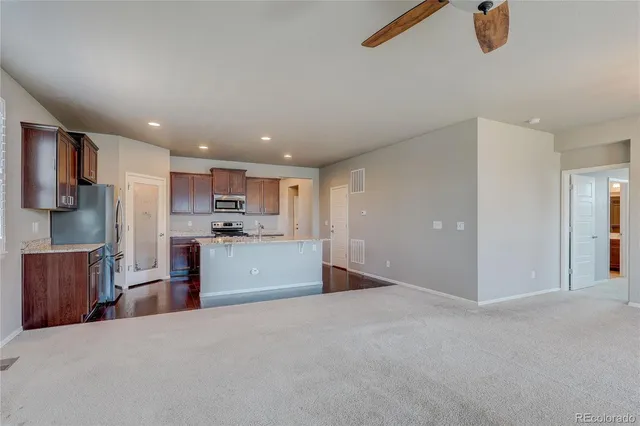 a view of a kitchen with refrigerator and window