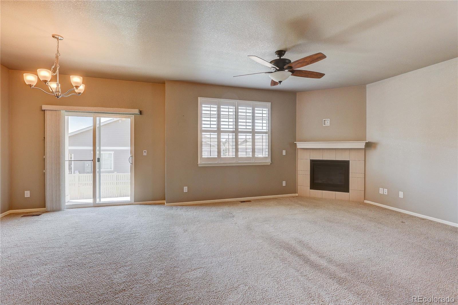 8891 Foxfire Street Firestone, CO 80504 - Photo 19 of 37 a view of an empty room with a fireplace and a window