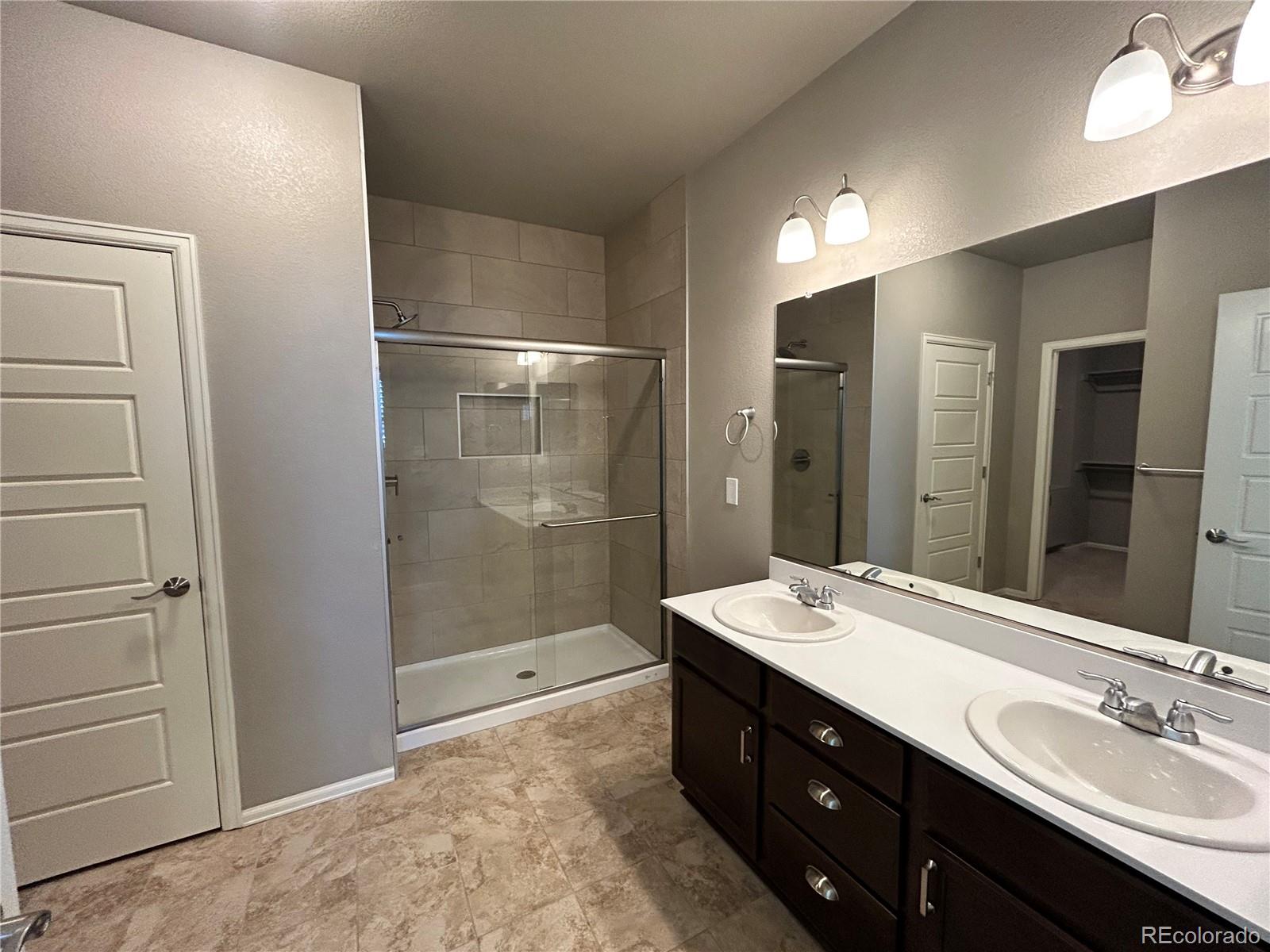 8891 Foxfire Street Firestone, CO 80504 - Photo 23 of 37 a bathroom with a double vanity sink mirror and shower