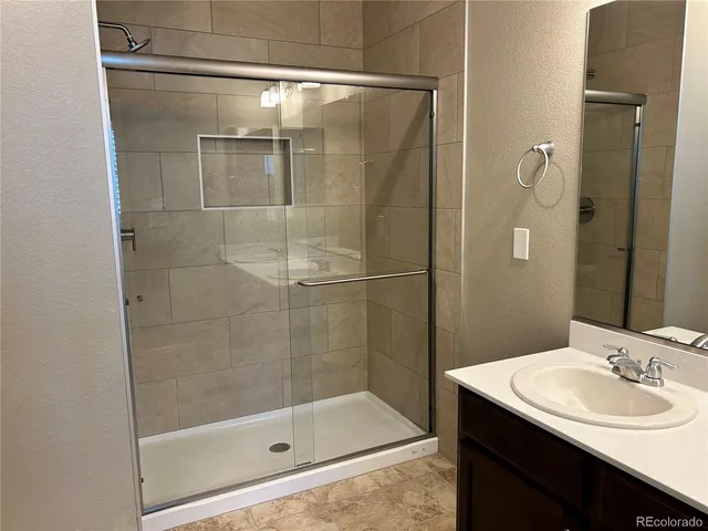 a bathroom with a shower a sink and mirror
