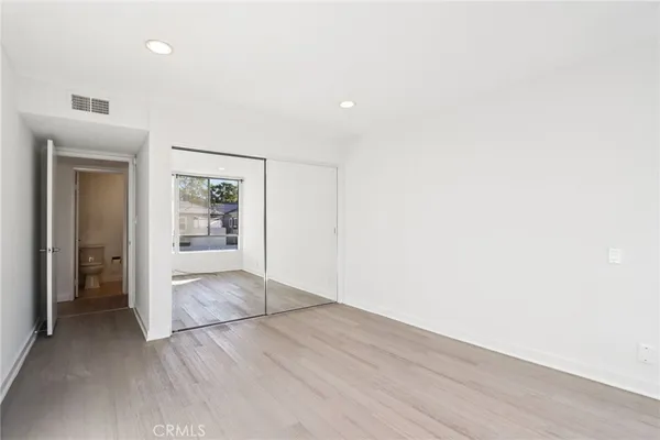 an empty room with closet and a bathroom