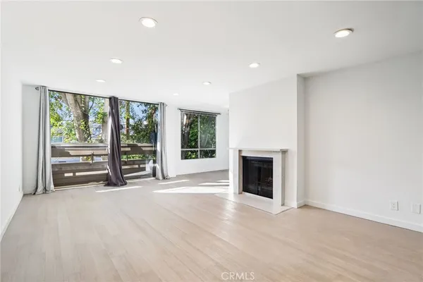 a view of an empty room with a fireplace and a window