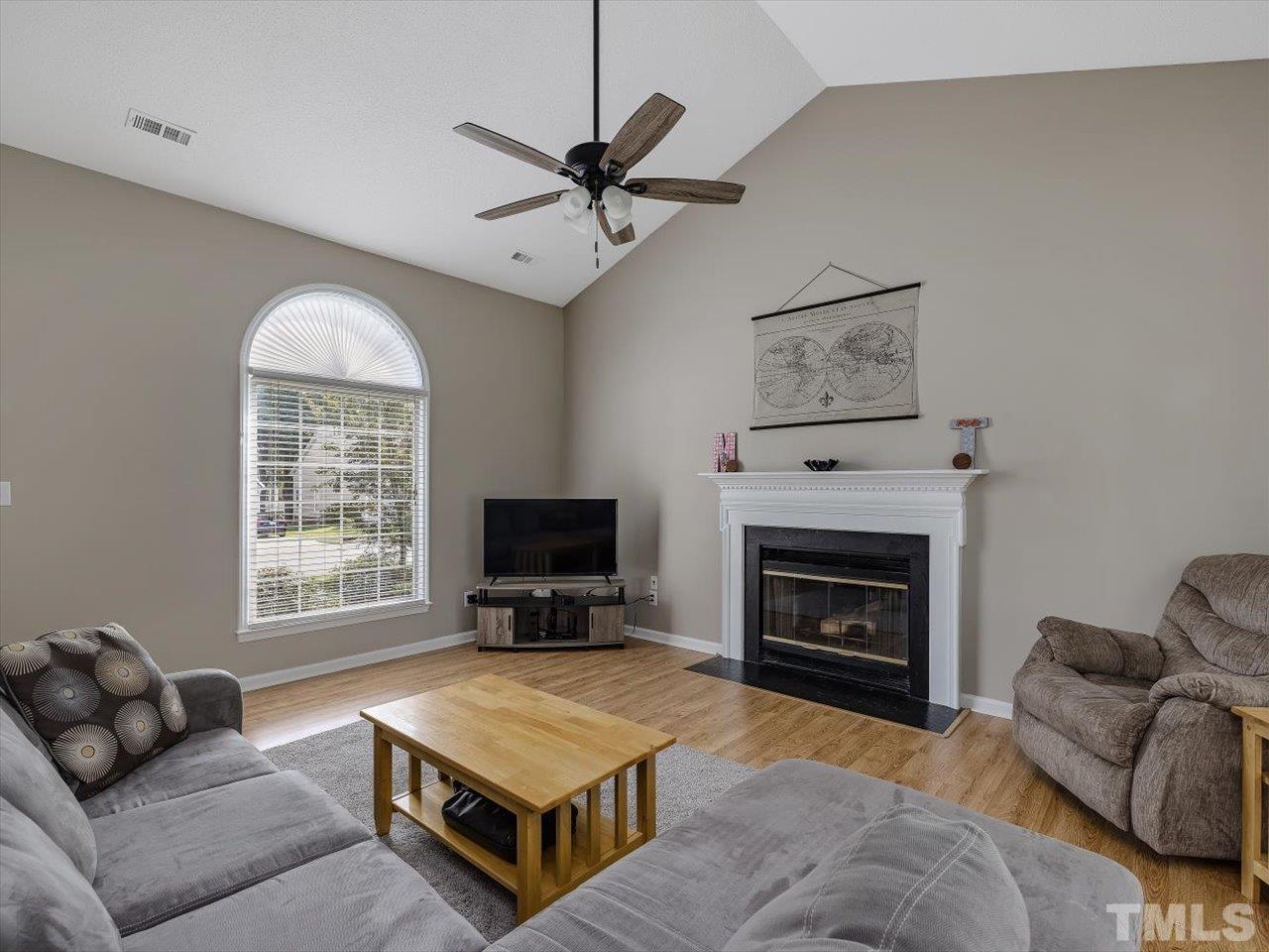 11220 North Radner Way Raleigh, NC 27613 - Photo 4 of 24 a living room with furniture a flat screen tv and a fireplace